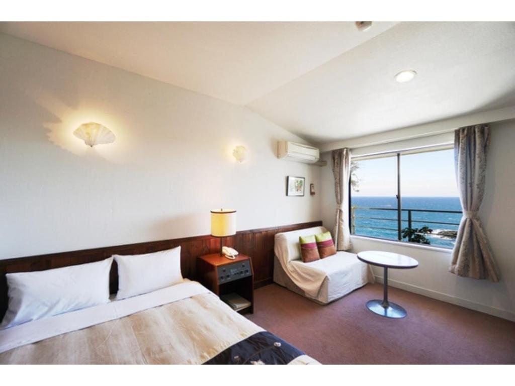 a bedroom with a bed and a table and a window at Garden Villa Shirahama - Vacation STAY 59275v in Shimoda