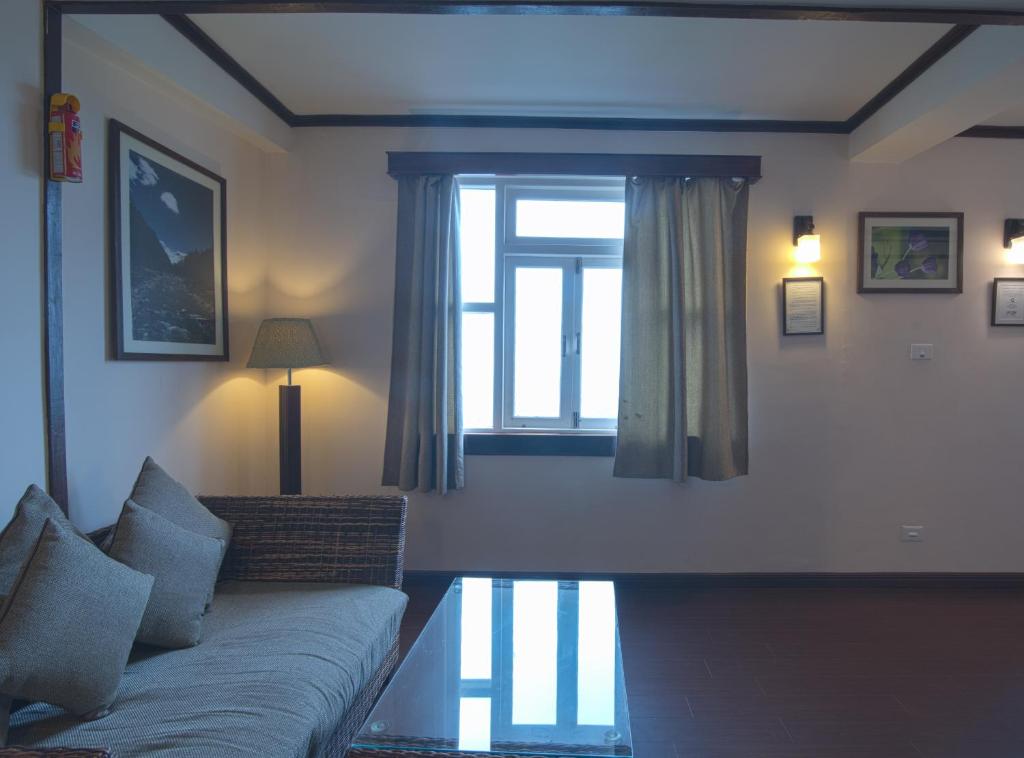 a living room with a couch and a window at The Nettle and Fern Hotel Gangtok in Gangtok