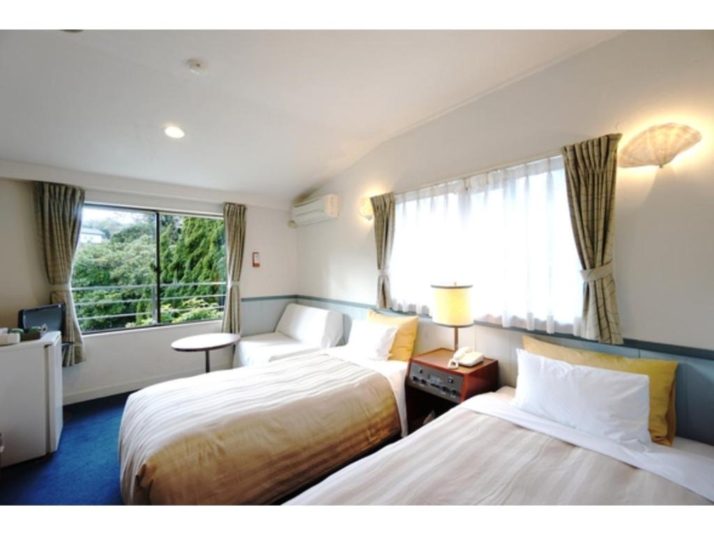 a hotel room with two beds and a window at Garden Villa Shirahama - Vacation STAY 59290v in Shimoda