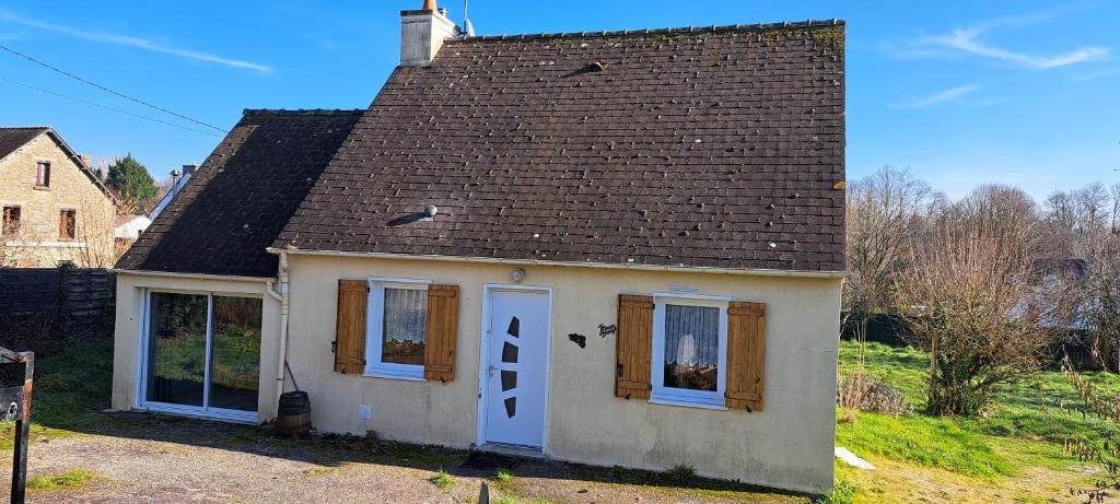 una piccola casa bianca con tetto marrone di Ty Coeur Breizh a Saint-Aignan