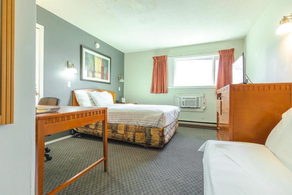A bed or beds in a room at Canadas Best Value Inn Kelowna