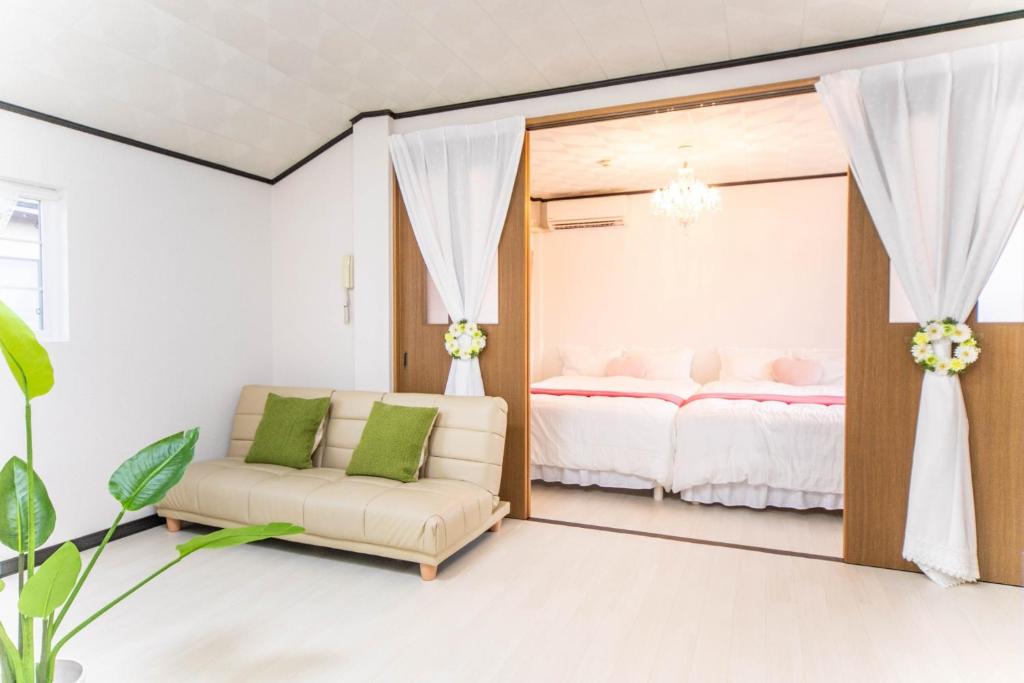 四日市市にある9 min to Yokkaichi Tomida STN House - Vacation STAY 14165のベッド1台、ソファ、鏡が備わる客室です。