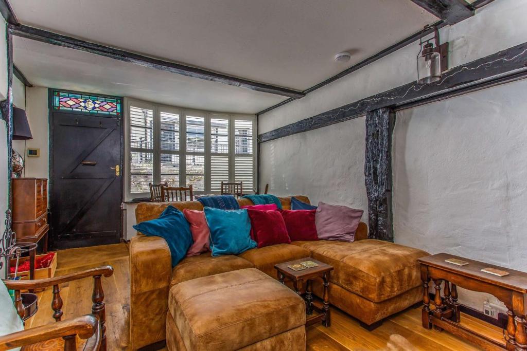 a living room with a large couch and a window at Modern living, Charming Old Town Cottage in Hastings