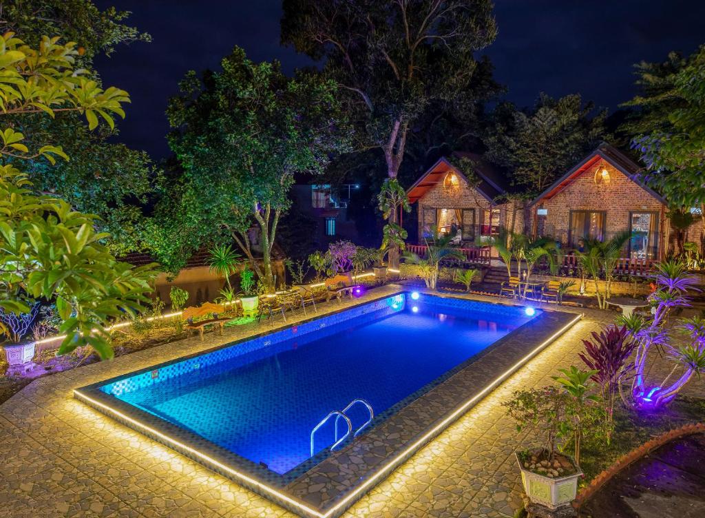 a swimming pool in front of a house at night at Cat Ba Spring Garden Homestay in Cat Ba