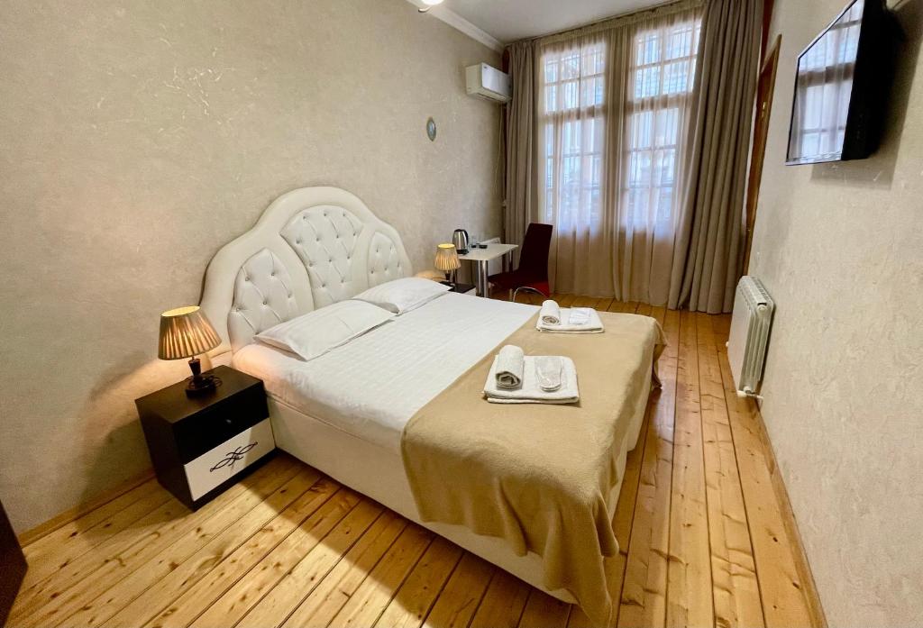 1 dormitorio con 1 cama grande y 2 toallas. en Guest House Lusi, en Tiflis