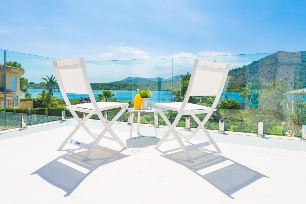2 weiße Stühle auf einem Balkon mit Meerblick in der Unterkunft NEW! Villa Lago B, Alcudia Beach, Mallorca in Port d'Alcúdia