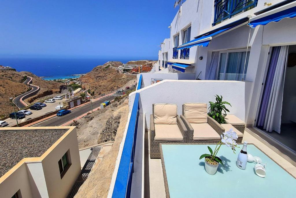 balkon z krzesłami i widokiem na ocean w obiekcie V&V Amadores Apartment w mieście Puerto Rico de Gran Canaria