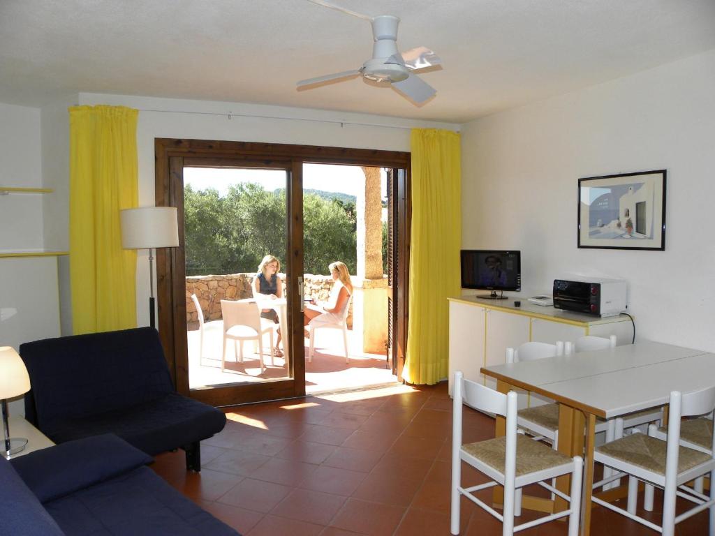 a living room with a couch and a table and chairs at Residence Bouganville in Porto Rotondo