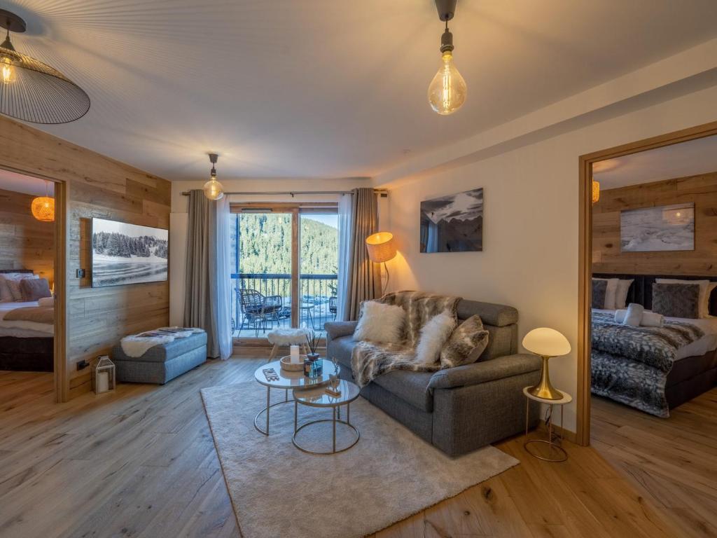un salon avec un canapé et une table dans l'établissement Appartement haut standing près des pistes avec parking, WiFi - FR-1-563-128, à Courchevel
