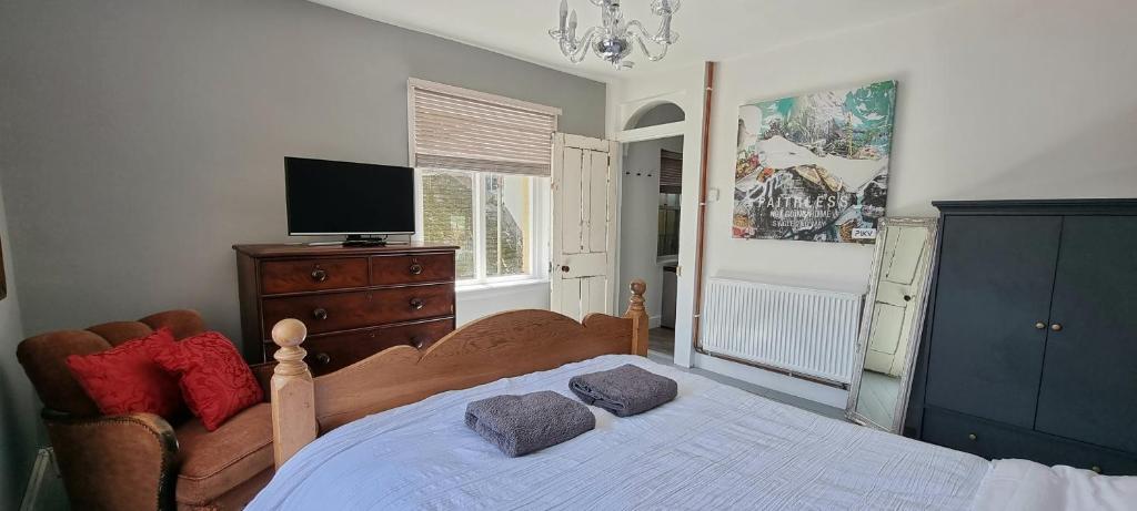 a bedroom with a bed with a television and a dresser at The Tuck Away, Central Old Town with Parking in Hastings