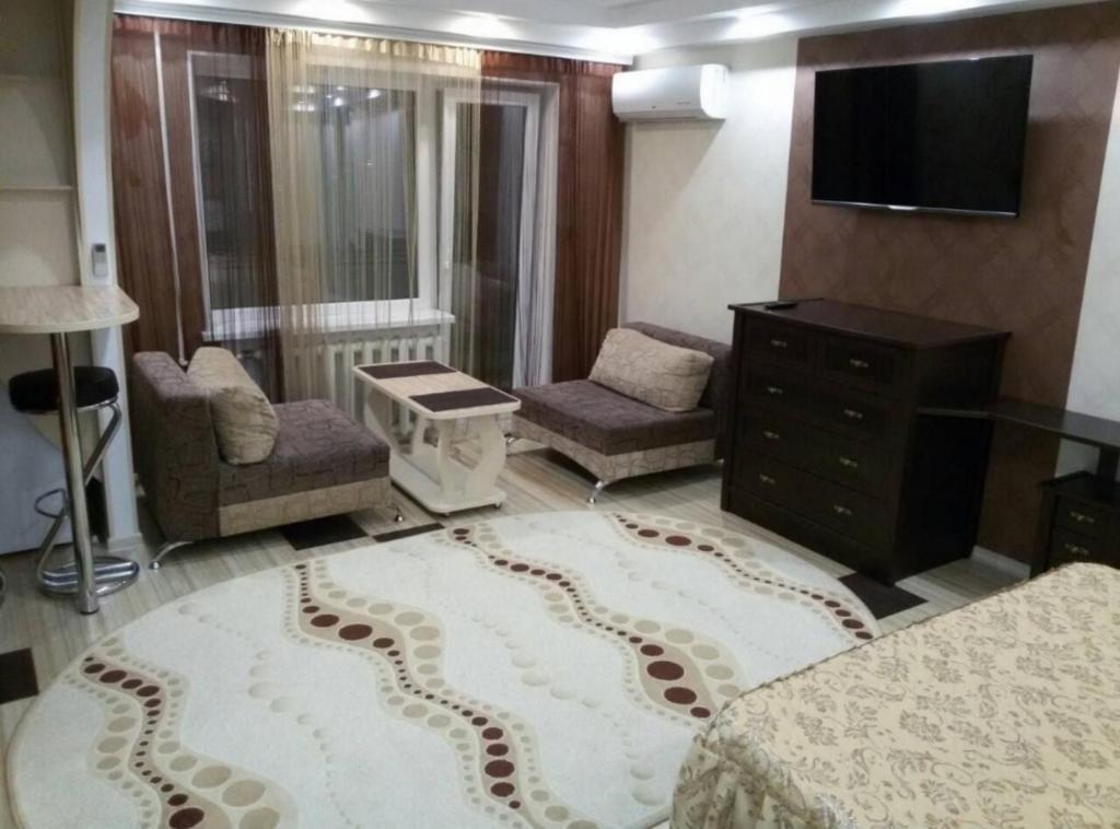 una sala de estar con sofá y TV y una habitación con sofá en Апартаменты Анжелика на Богоявленском проспекте en Mykolaiv