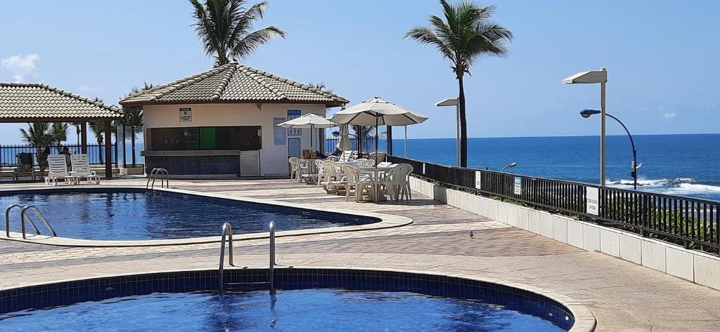 a resort with a swimming pool and the ocean at Marazú OndinaApart in Salvador