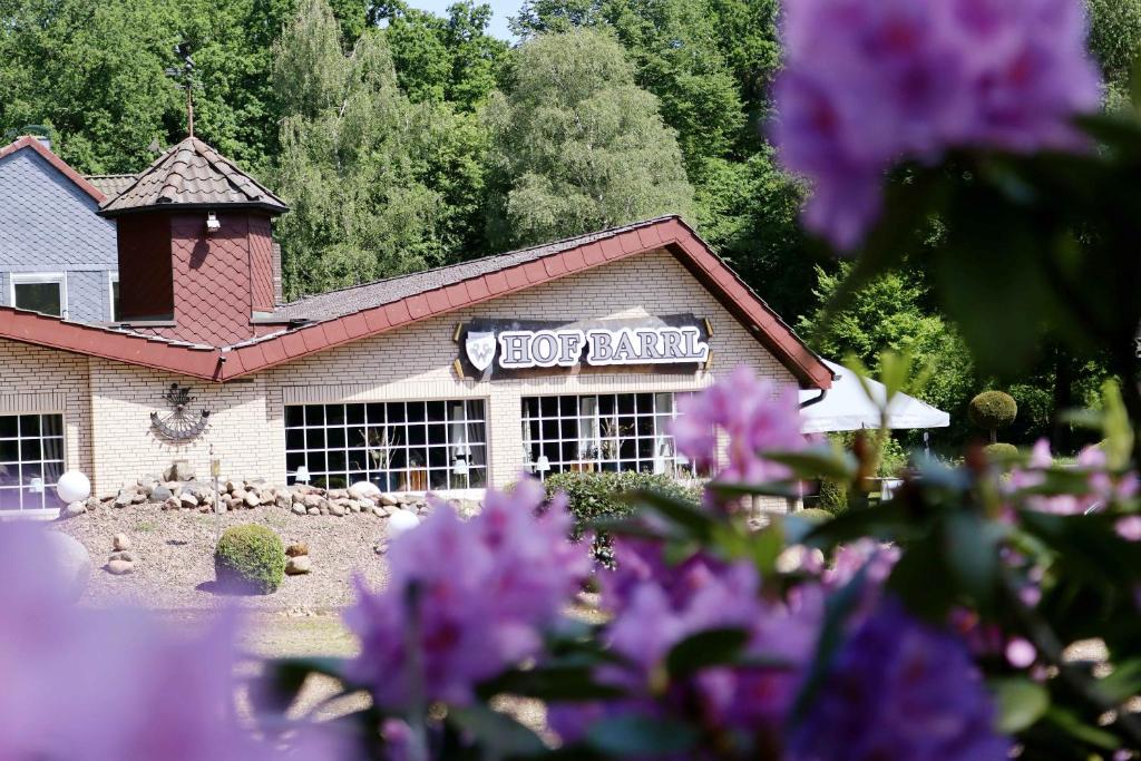een restaurant met paarse bloemen ervoor bij Landhotel Hof Barrl in Schneverdingen