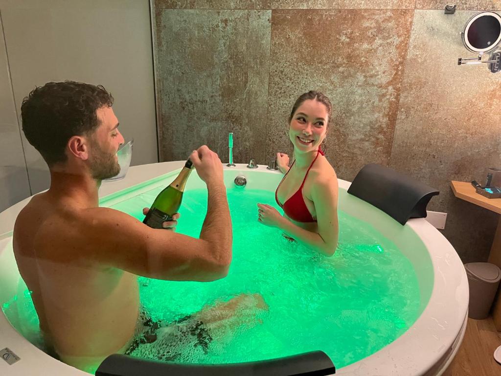 a man and woman in a bath tub with a bottle of champagne at Centro Storico Bed e Breakfast in Pozzuoli