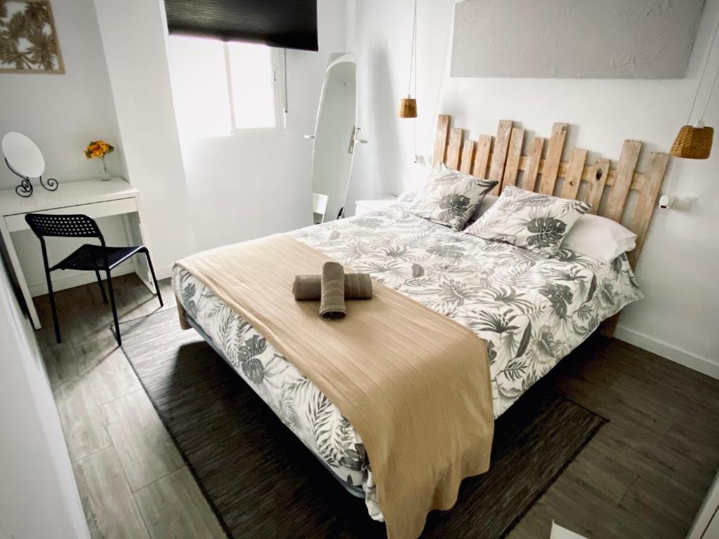 una camera con un grande letto con testiera in legno di Apartamento Vistafranca a Málaga