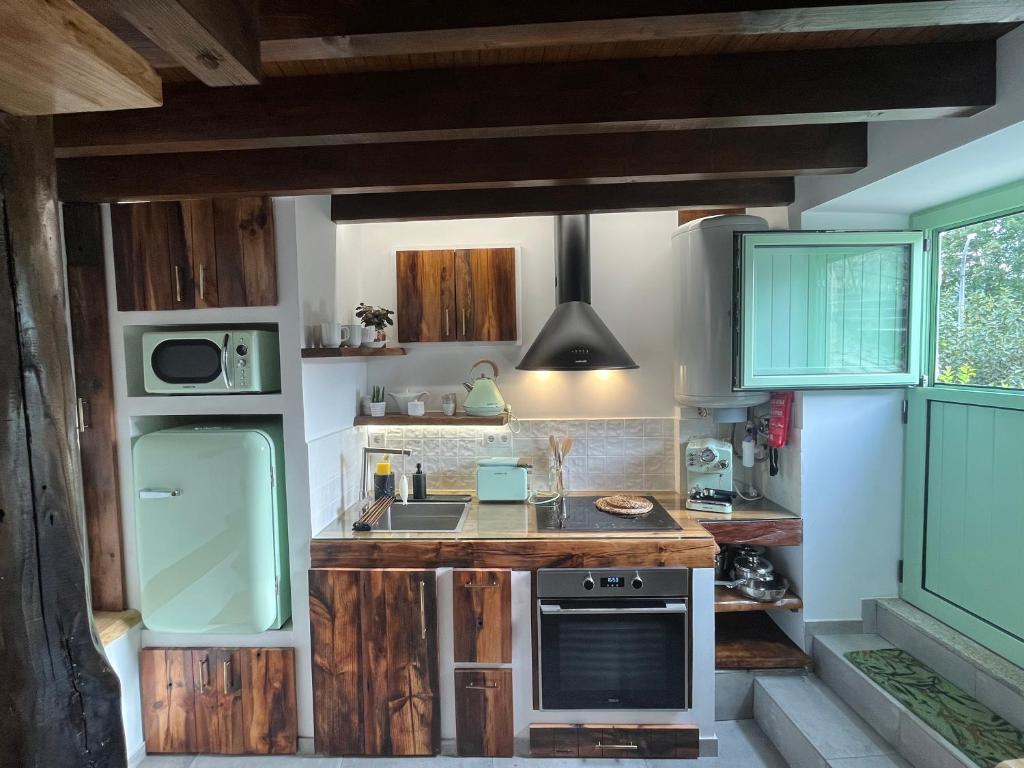 a kitchen with wooden cabinets and a sink and a stove at Casa da Linha in Amarante