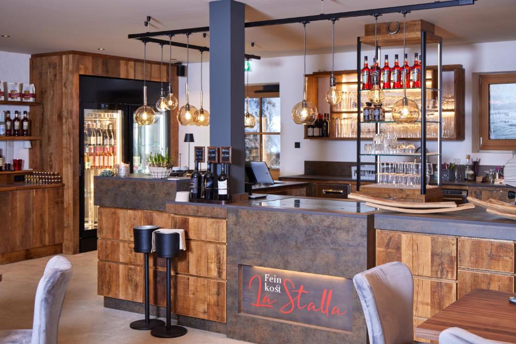 a bar at a restaurant with a counter and chairs at Gästehaus Brandnerhof in Garmisch-Partenkirchen