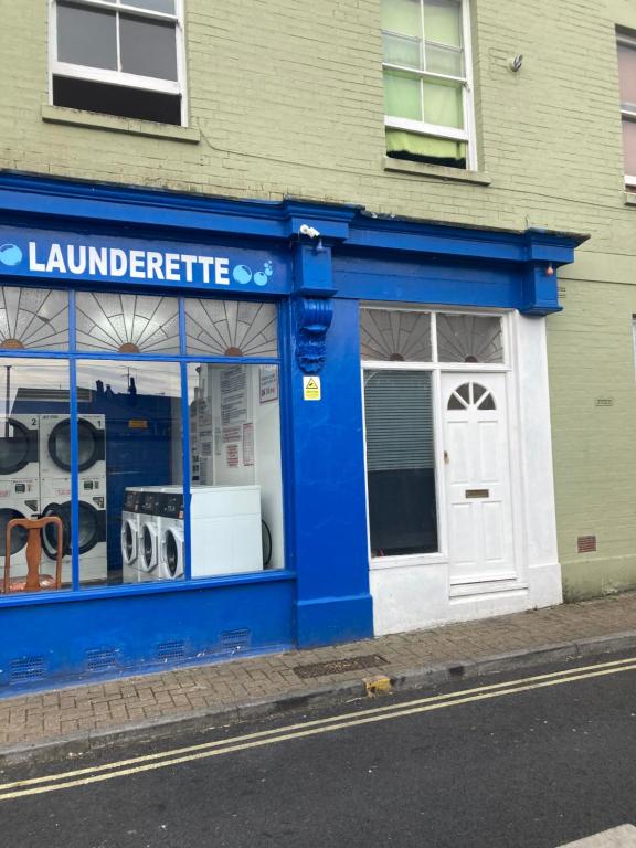 una tienda azul frente a un edificio con garaje en Lovely Studio Flat @ 10C Nearby Sea Front, en Ryde