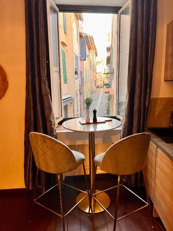 une table et deux chaises devant une fenêtre dans l'établissement CALANQUE DE PORT PIN, à Cassis