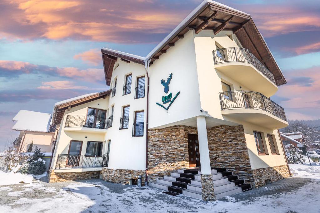 una casa in inverno con neve per terra di Emerald Residence a Rîşnov