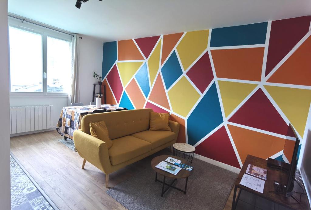 a living room with a couch and a colorful wall at Quatre Moulins - 3 chambres - WIFI - Refait à neuf in Brest