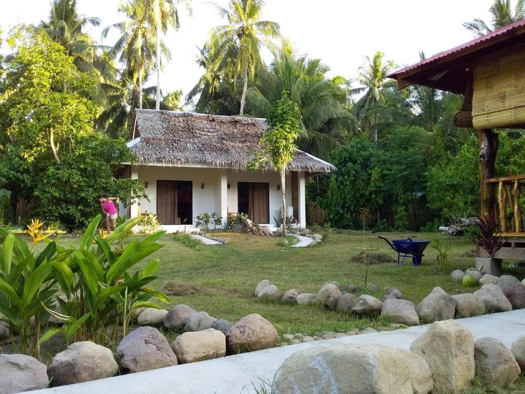 a house in the middle of a yard at Happy Coconut Camiguin in Mambajao