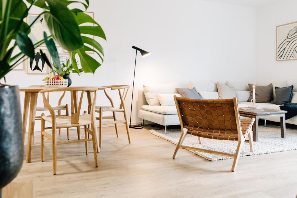 sala de estar con mesa, sillas y sofá en Ferienwohnung Nordic Calm am Kellersee, en Malente