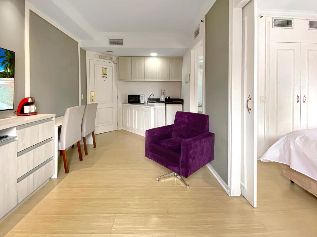 a purple chair in a room with a kitchen at Hotel deslumbrante na Vila Olimpia in Sao Paulo