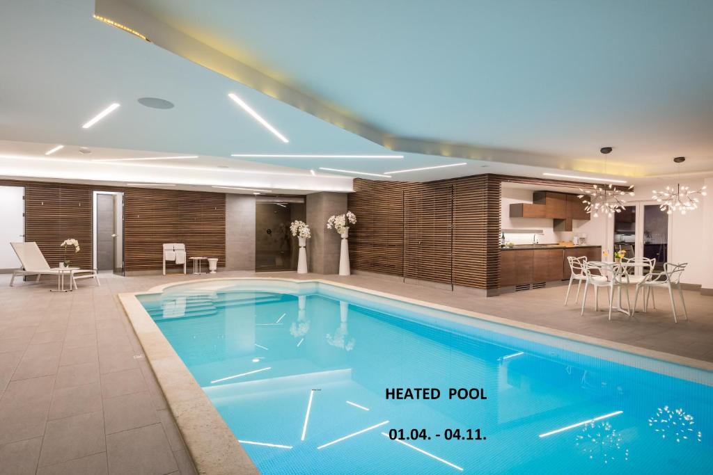einen großen Pool mit einer Küche und einem Esszimmer in der Unterkunft Plage Lovran Residence in Lovran