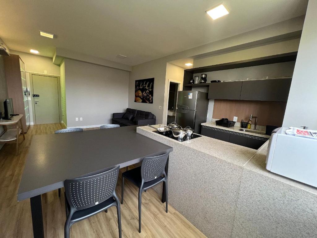uma cozinha e sala de estar com mesa e cadeiras em Locking's Santo Agostinho 4 em Belo Horizonte