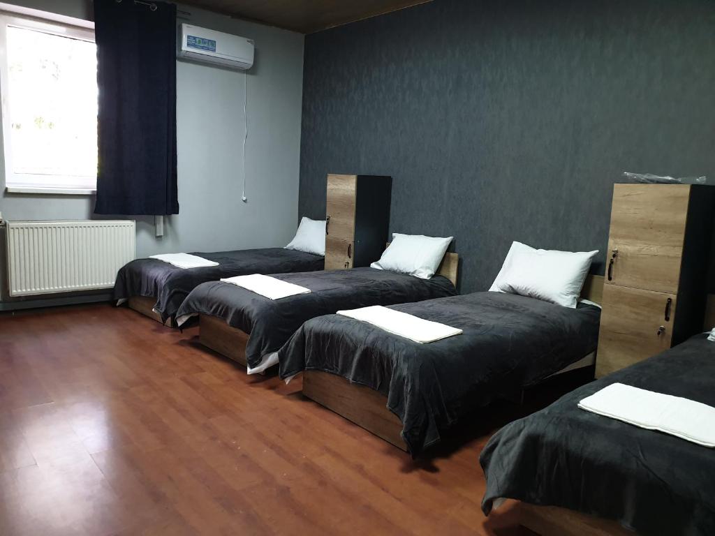 three beds in a room with wood floors at Мандри Хостел in Uzhhorod