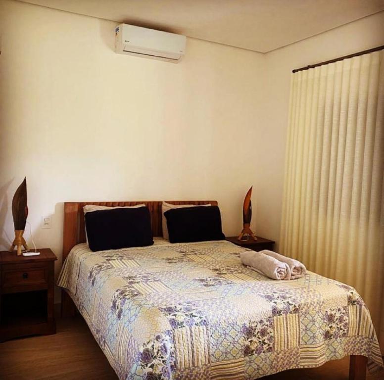 Un dormitorio con una cama con una manta. en Magia da Serra Casa Temporada en Pirenópolis