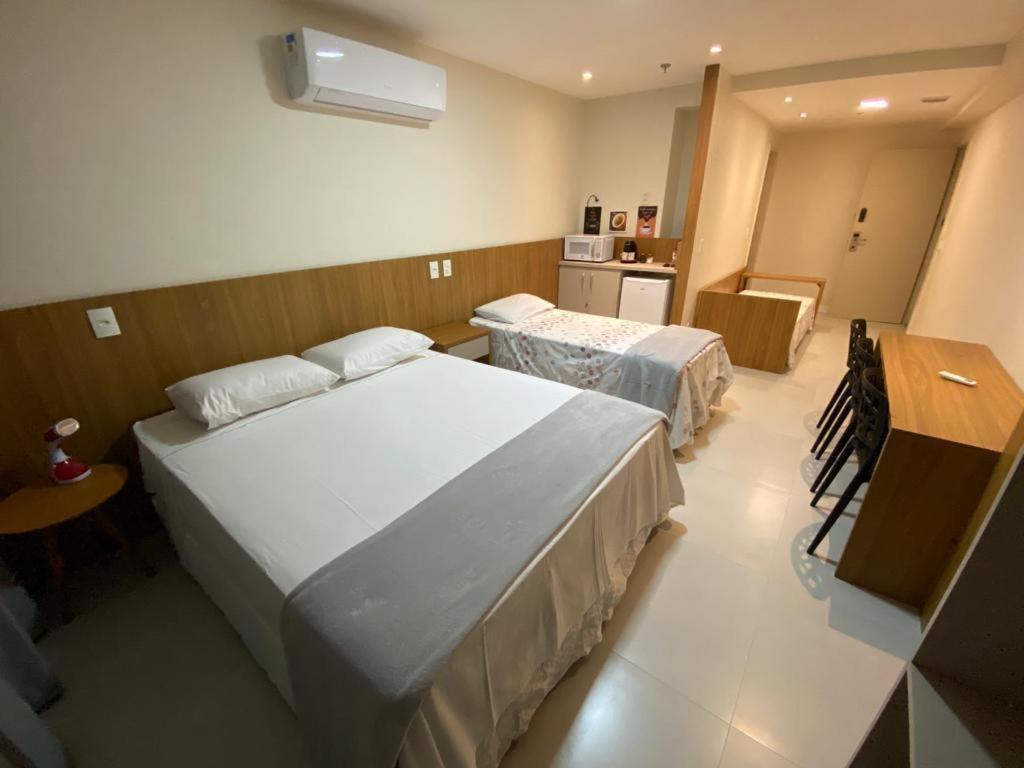 a hotel room with two beds and a kitchen at Quarto para 4 pessoas in Campos dos Goytacazes