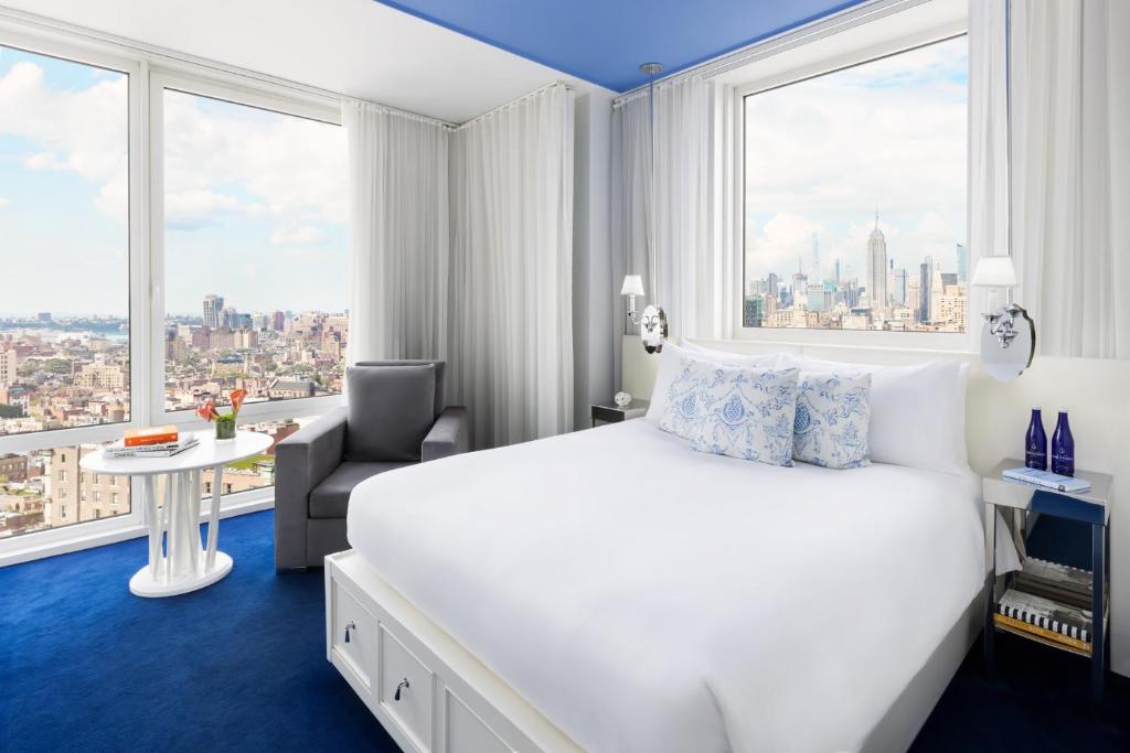 ニューヨークにあるノモ ソーホーのベッドと大きな窓が備わるホテルルームです。