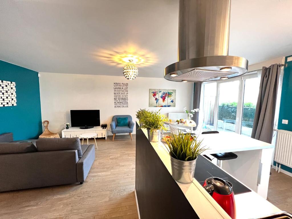 a kitchen and living room with a couch and a table at Paris La-Defense - U Arena - 2 Bedrooms - Parking, Terrace & Wifi in Nanterre