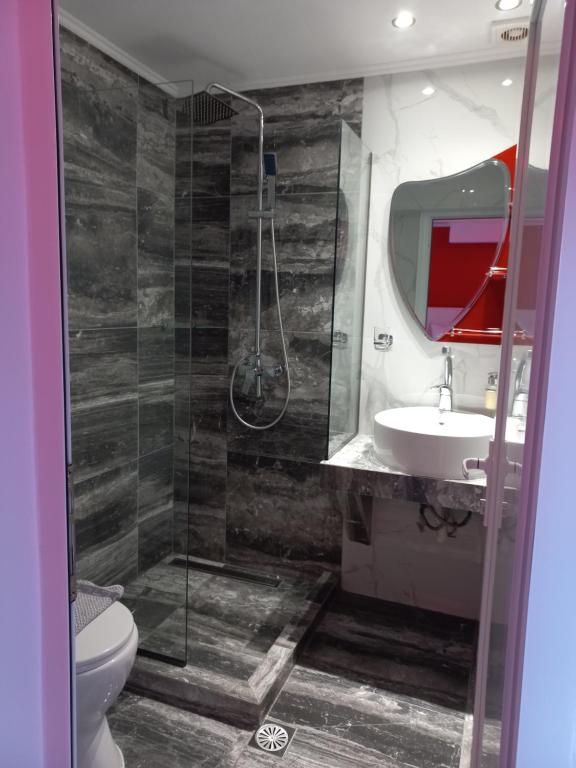 a bathroom with a shower and a toilet and a sink at House Blerina in Sarti