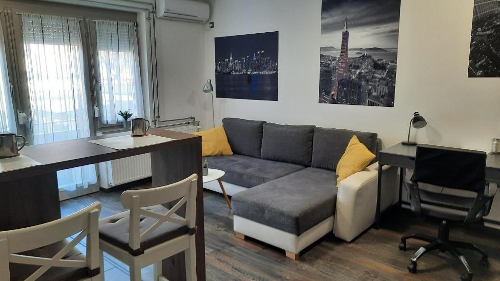 sala de estar con sofá y escritorio en Pete Lajos Design Apartman, en Kaposvár