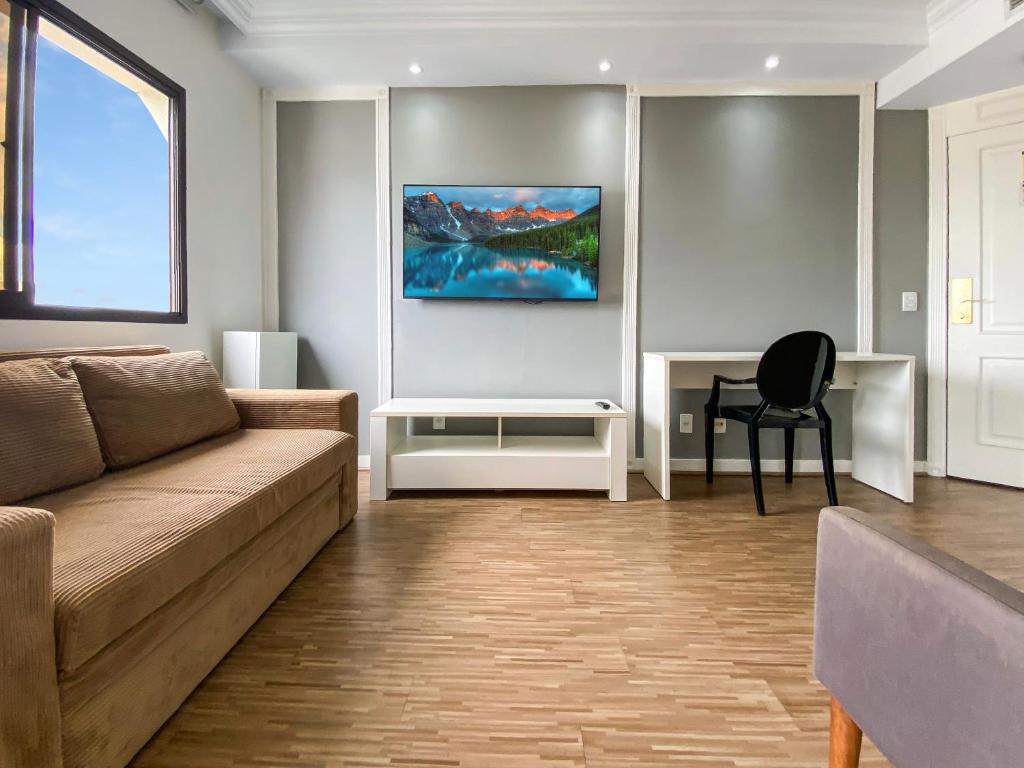 uma sala de estar com um sofá e uma secretária em Hotel com piscina e academia na Gomes de Carvalho em São Paulo