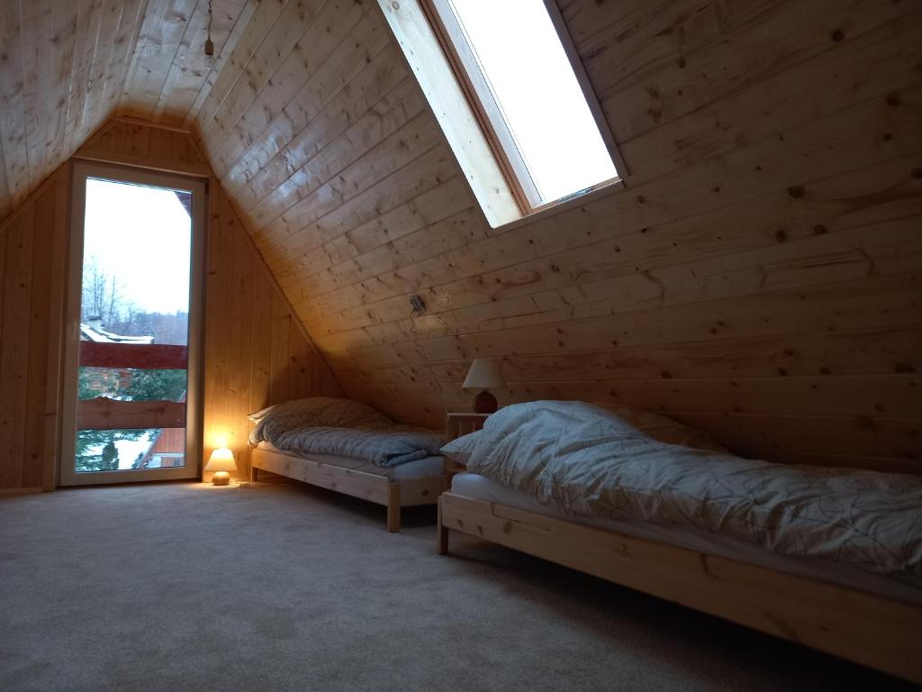 una camera con 2 letti in una cabina di legno di Domek Bacówka Pod Lipą a Lipowa
