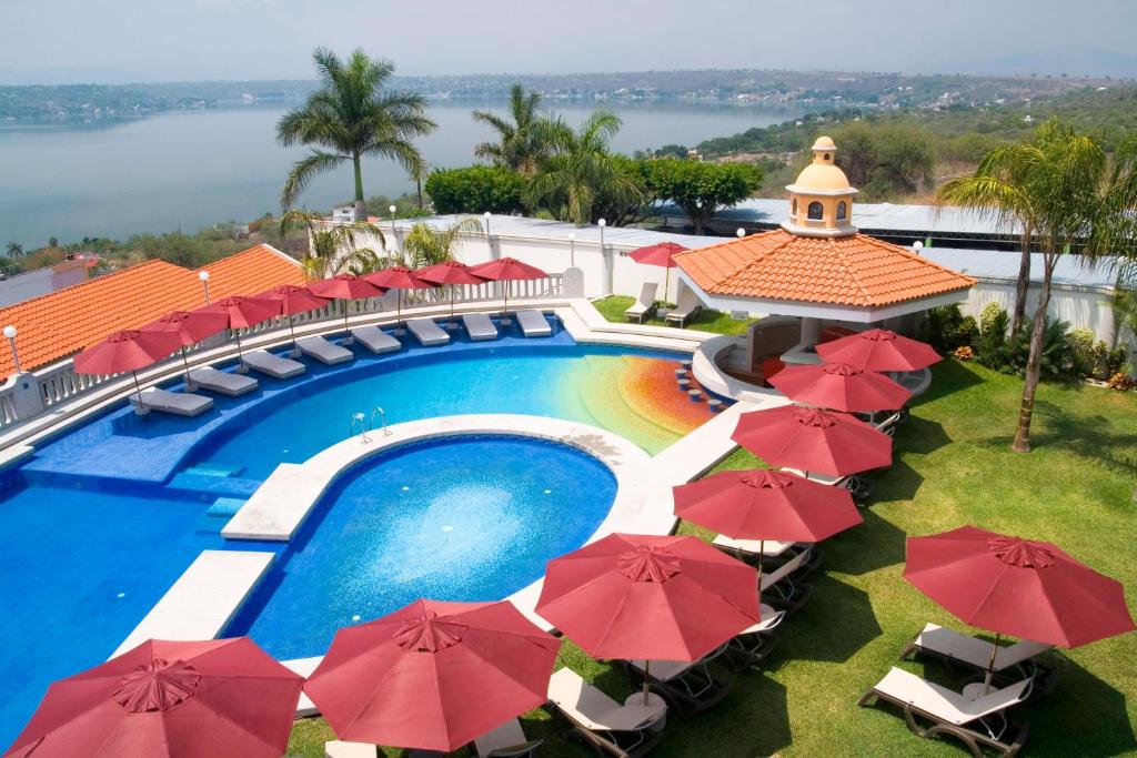 una vista aérea de una piscina del complejo con sombrillas rojas en Excelaris Grand Resort Conventions & Spa, en Tequesquitengo
