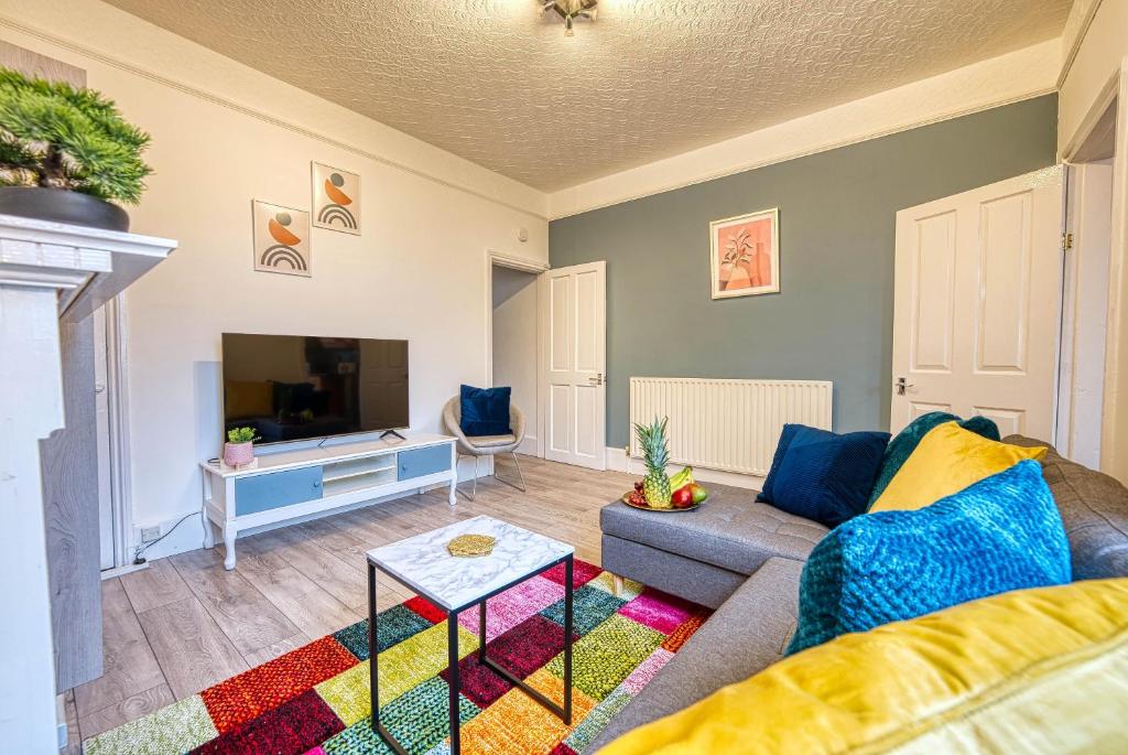 a living room with a couch and a tv at Stylish & Cosy in Coventry Garden Parking in Coventry