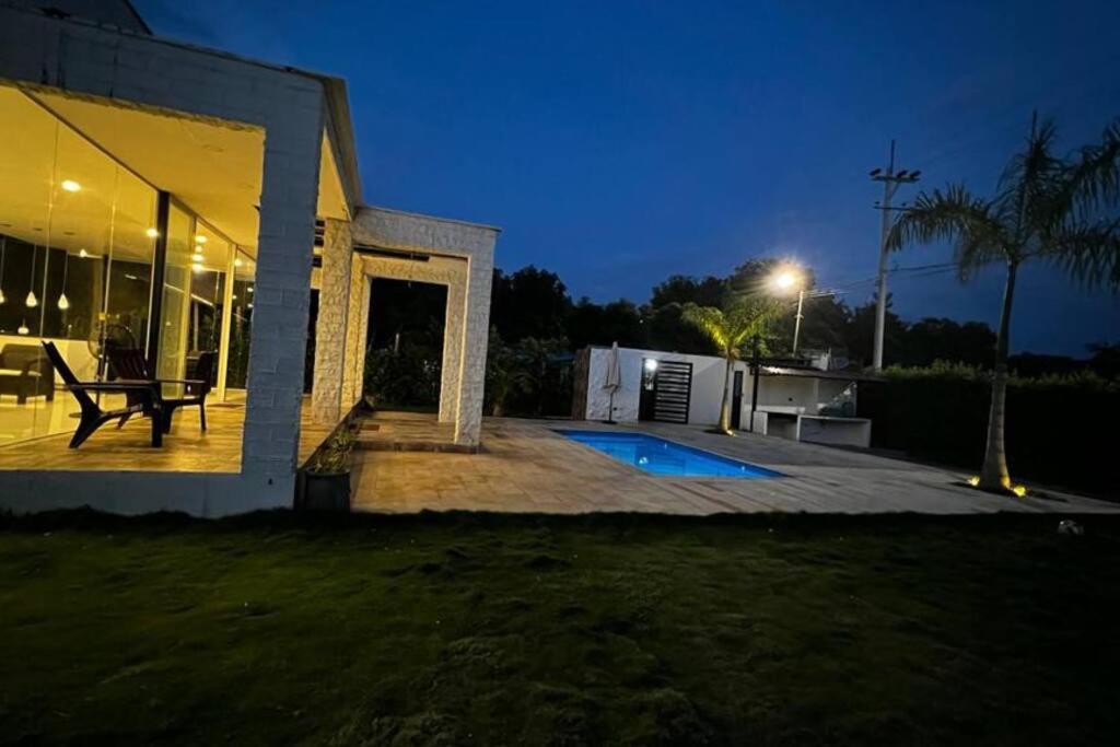 ein Haus mit einer Terrasse und einem Pool in der Nacht in der Unterkunft ¡Quinta al Cielo! in Girardot