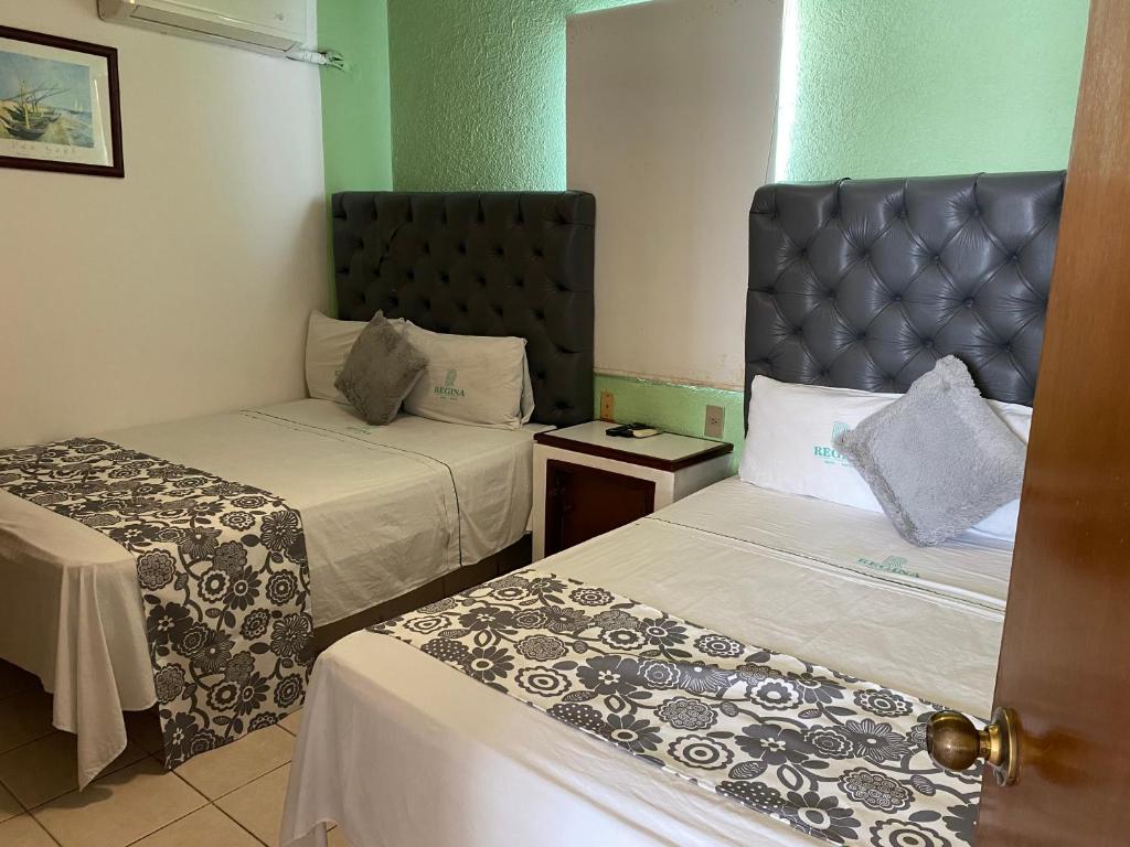 Postel nebo postele na pokoji v ubytování Hotel Suites Regina