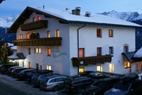 a large white building with cars parked in front of it at Hotel Garni Sonnenheim in Fiss