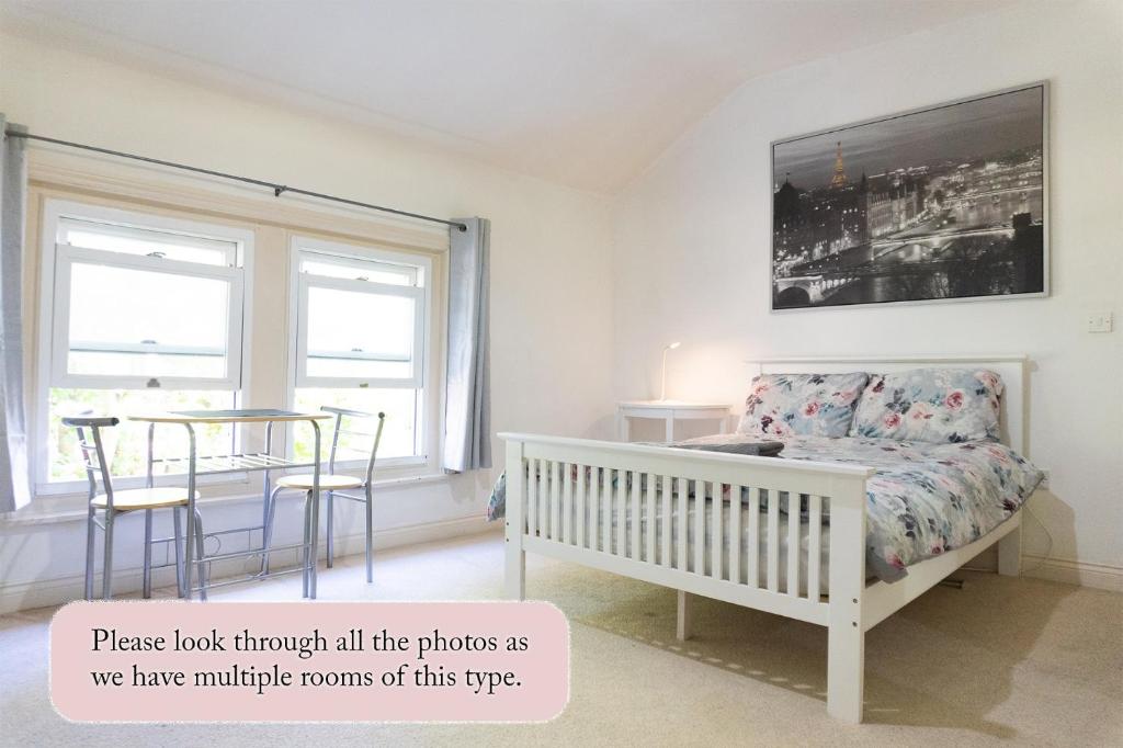 a bedroom with a crib and a table and a window at Elphinstone HomeShare in Portsmouth