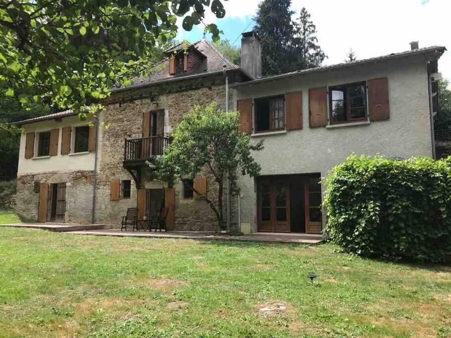 an old stone house with a balcony and a yard at Ancient Mill with Beautiful Lake and Streams in Les Riffes