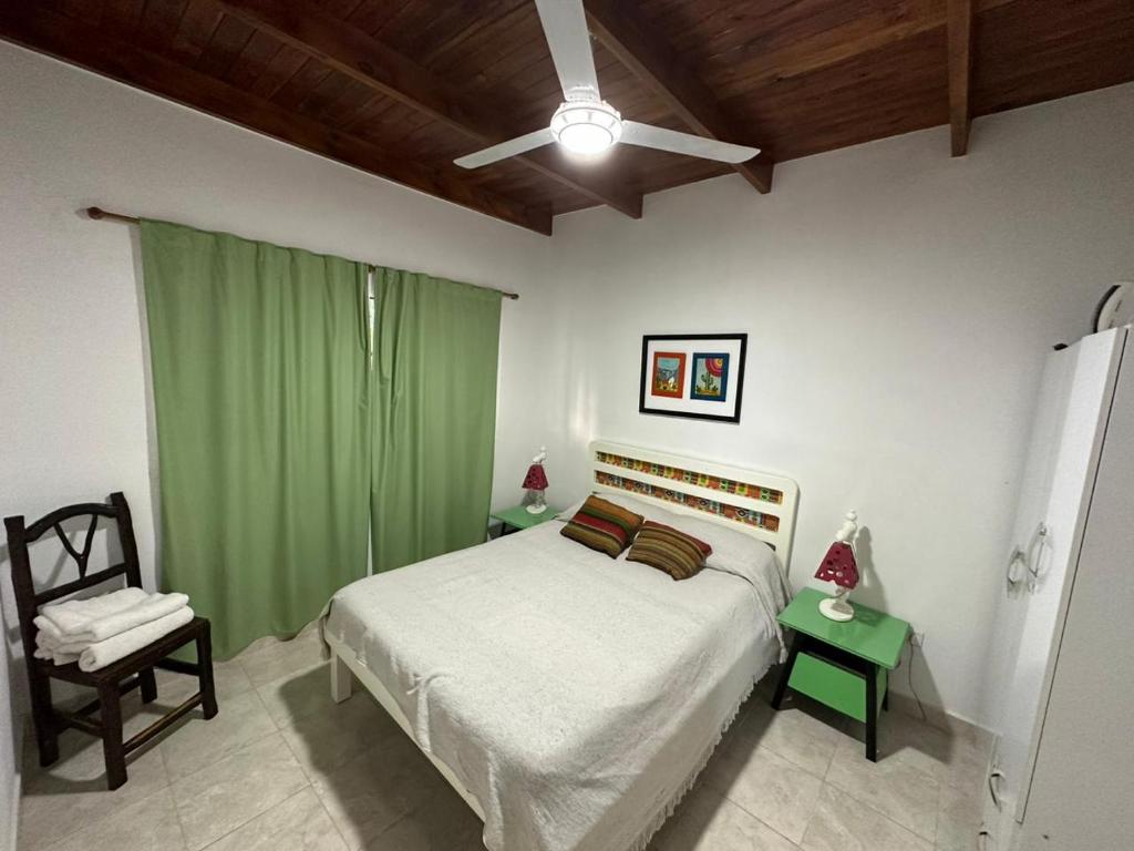 a bedroom with a bed and a green curtain at Cabañas Peumayén Salta in San Agustín