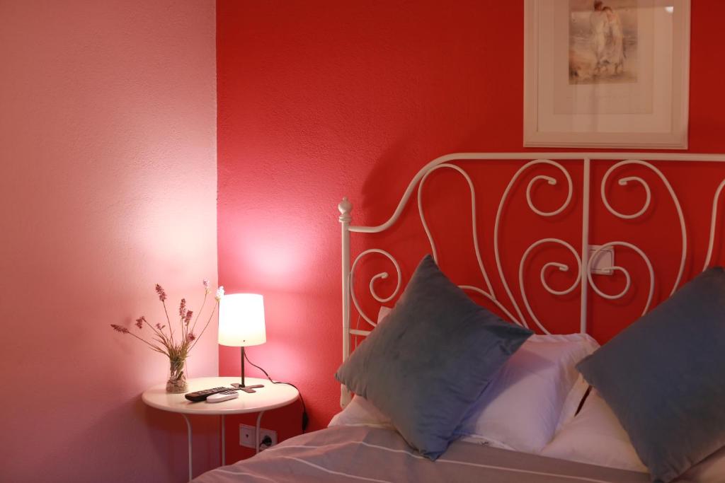 a bedroom with a bed with a red wall at Artemis Apartment,Beach two-bedroom in Artemida