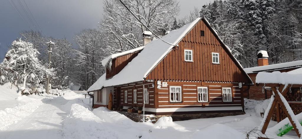 ein Holzhaus mit Schnee auf dem Dach in der Unterkunft Chalupa Čistá v Krkonoších 8 in Černý Důl