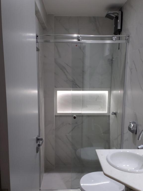 y baño con ducha, aseo y lavamanos. en Apartamento reformado, tudo novo, Copa-Ipanema, en Río de Janeiro